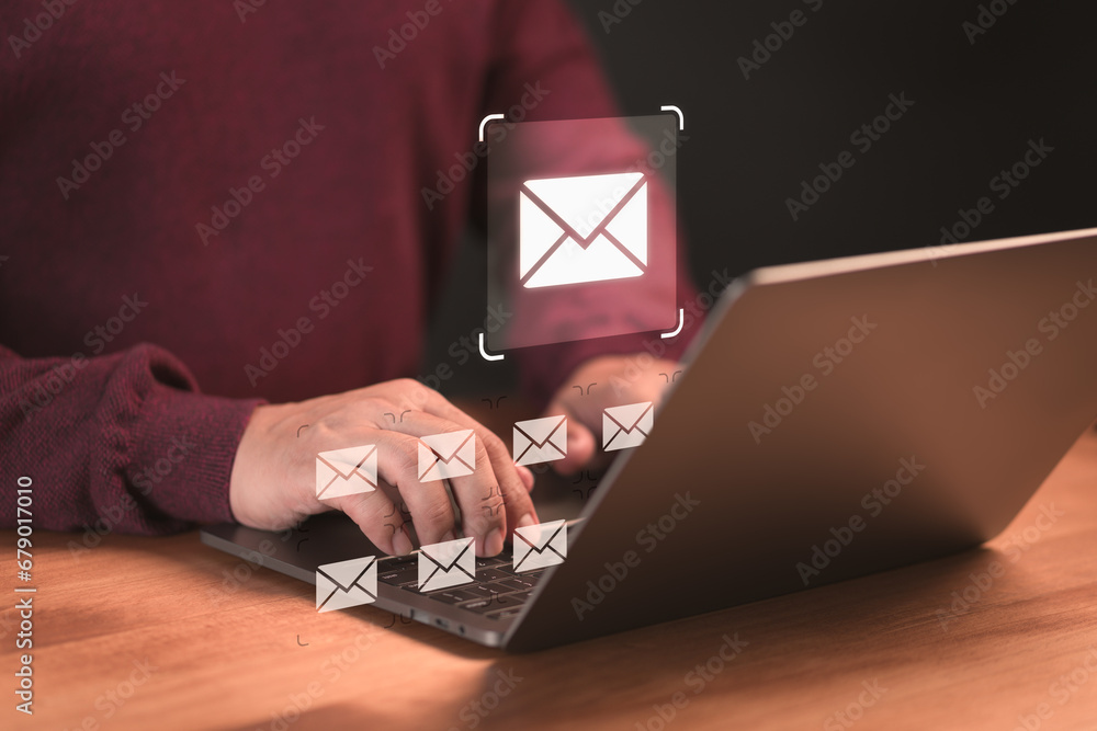 Poster Concept of Email marketing, send e-mail or news letter, online working internet network. Male hand using a computer laptop typing on keyboard and surfing the internet on office table with email icon.