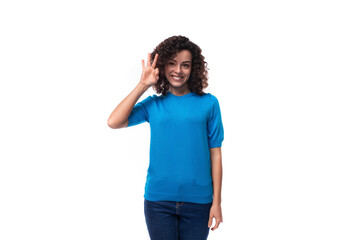 young brunette lady with curly hair is dressed in a blue blouse and shows ok