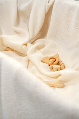 Muslin blanket and wooden toys in baby cradle