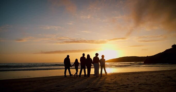 Family, walk and holding hands with silhouette, beach and sunset with freedom, vacation and outdoor together, Men, women and children by ocean, sand and waves with back, love and support in Mexico