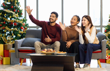 Millennial Asian Indian multinational cheerful male female friends celebrate Christmas Eve Happy...