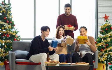 Millennial Asian Indian multinational cheerful male female friends celebrate Christmas Eve and...