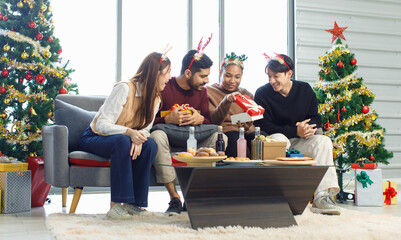 Millennial Asian Indian multinational cheerful male female friends celebrate Christmas Eve and...