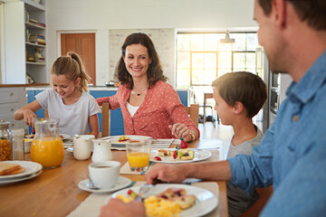 Smile, food and morning with a family in the dining room of their home together for health or nutrition. Mother, father and happy sibling kids eating breakfast at a table in an apartment for bonding