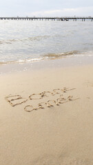 happy new year in french text sign means bonne annee write at beach sand with sea wave foam
