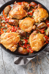 Chicken Scarpariello is an easy dinner made with chicken, sausage, pepper closeup on the plate on the table. Vertical top view from above