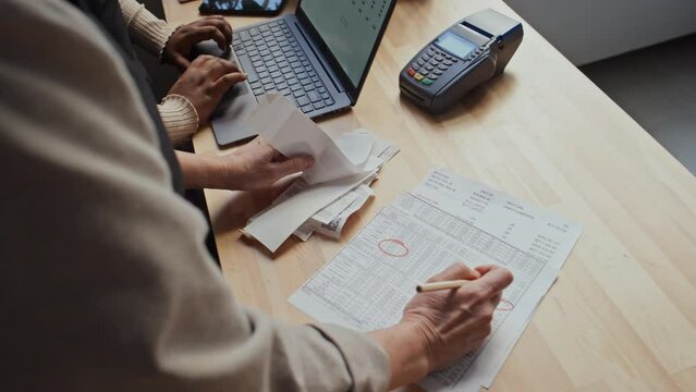 High angle shot of unrecognizable two small business owners looking through bills