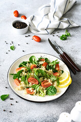 Salad with quinoa tomatoes and spinach on a light background