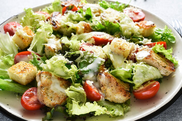 Caesar salad with chicken, cheese and tomatoes