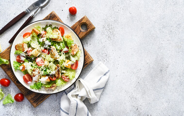 Caesar salad with chicken, cheese and tomatoes