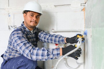 Indian plumber installing water equipment - meter, filter and pressure reducer