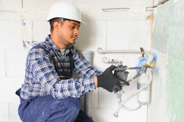 Indian plumber installing water equipment - meter, filter and pressure reducer