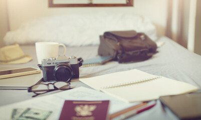 Fototapeta na wymiar Travel, luggage and Necessary items for trip on bed with coffee for morning, camera and suitcase for adventure, holiday and vacation. traveling lifestyle and freedom for journey
