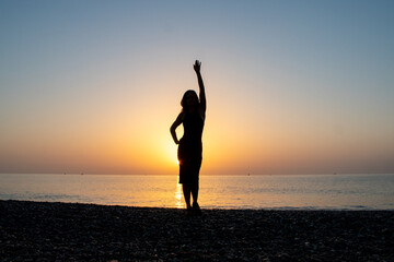 Fototapeta premium silhouette of a girl on the seashore advertising photo