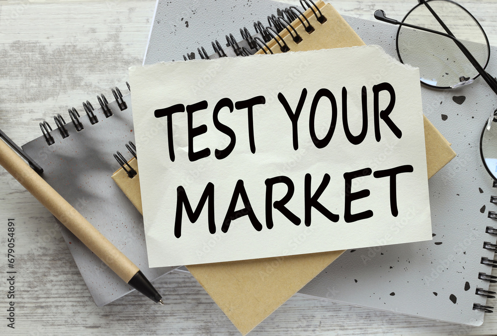 Poster test your market. text on a page on a gray notepad on the table