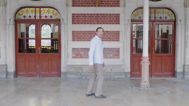 A man walks along the old railway station building in Istanbul and looks back in surprise