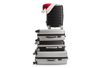Pile of suitcases with a santa claus hat on top