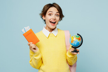 Traveler fun student woman wear casual clothes hold passport ticket globe isolated on plain blue...