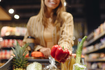 Cropped young customer woman wear casual clothes hold bell pepper shopping at supermaket store...