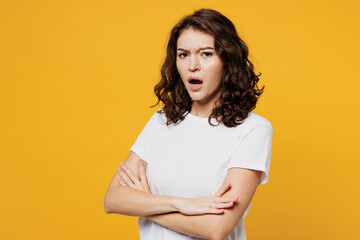 Young frowning sad mad Caucasian woman she wear white blank t-shirt casual clothes put hands...