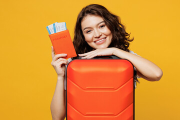 Traveler woman wear casual clothes hold passport ticket bag isolated on plain yellow orange...