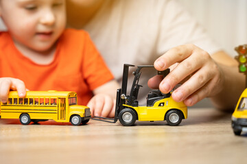 Father and son play with cars. Spending time with children. The concept of a happy childhood....