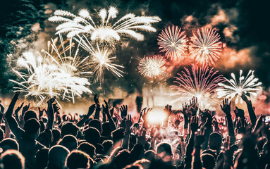 Obraz na płótnie Canvas crowd with raised hands and fireworks new year banner