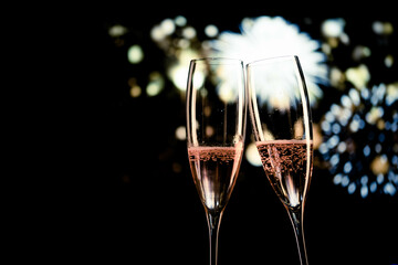 two champagne glasses and festive light happy New Year