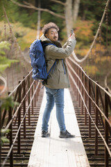 トレッキングや登山して撮影する男性　秋の風景　カメラ目線