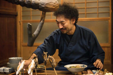 Bearded man enjoying a meal during a stay at a ryokan on a trip to Japan.