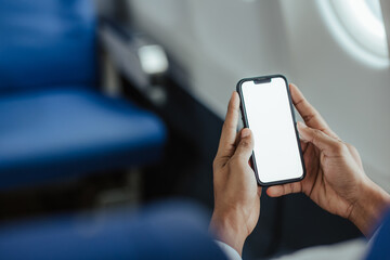 A young man uses a smartphone with a blank screen while boarding an airplane.