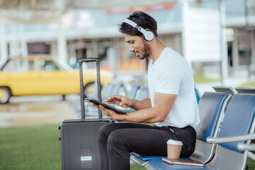 Fototapeta na wymiar A young man uses the internet in an airport terminal.