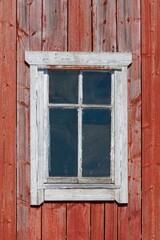 Old white painted framed window on a wood building.
