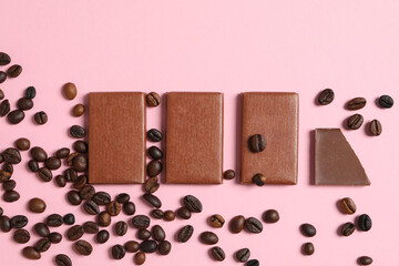 Chocolate bars with coffee beans on a pink background