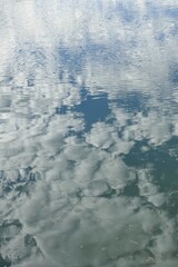 Reflection of cloudy sky on calm sea surface in spring.