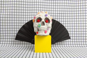 a skull covered with multiple plastic flowers wearing Count Dracula's high-collared cape