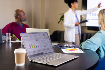Focused diverse male and female medical staff listening and giving presentation at office meeting