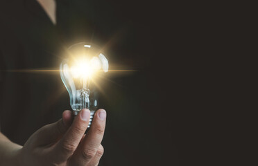 Idea innovation and inspiration concept. Hand of man holding illuminated light bulb, concept...