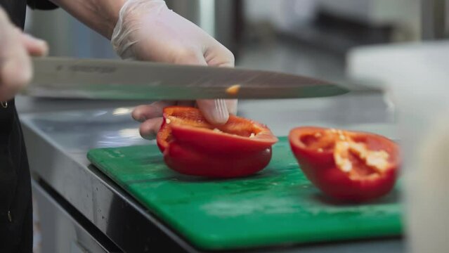 Professional cook preparing sweet bell pepper ingredient for the meal. Preparing pepper ingredient by removing the seeds. Preparing the pepper ingredient by Carving out the part with seeds. Vegetable