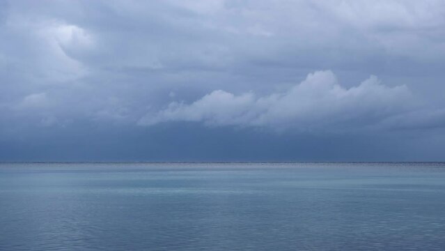 Magnificent nature landscape at the beach with amazing wind stripes on the water surface. Only blue and turquoise colours. Clouds moving above the mountains of Cres Island, Croatia on a stormy day.