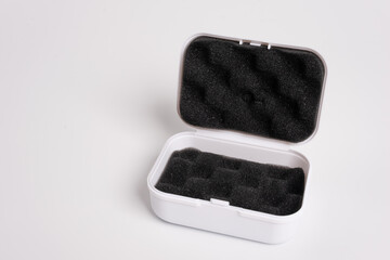 White open box lined with black sponge inside, isolated on a white background. Black mini pouch bag...