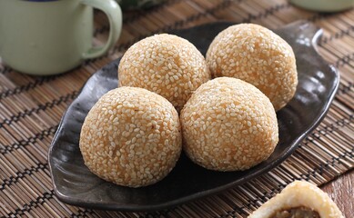 Onde Onde is a round cake with sesame seeds sprinkled on the outside and green beans on the inside