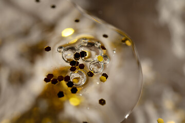 Cosmetic product with air bubbles and glitter on festive glitter background