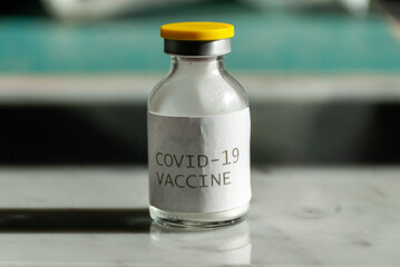 Sars-cov-2 vaccine vial bottle on marble table.