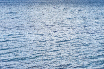 Water surface of sea with slight waves in cloudy weather, close-up
