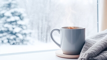 Obraz premium Winter holidays, calm and cosy home, cup of tea or coffee mug and knitted blanket near window in the English countryside cottage, holiday atmosphere