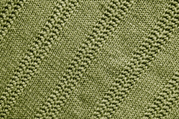 green knitted texture. Abstract background, pattern, ornament. Detail of a warm winter sweater.