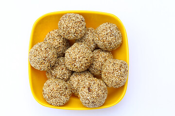 Indian sweet sesame laddu or til laddu in a bowl on white background 