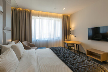 Interior of a luxury double bed hotel bedroom in the morning