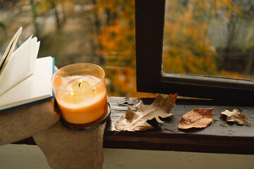 Sweet Home. Still life details in home on a wooden window. Candle and autumn decor. Autumn home decor. Cozy fall mood. Cozy autumn or winter concept.